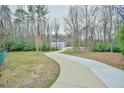 Curving driveway leading to a modern home surrounded by trees and expansive lawn at 4908 Birchleaf Dr, Raleigh, NC 27606