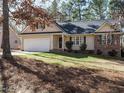 Charming one-story home featuring a 2-car garage, brick accents, and lush front lawn at 504 Forrest Dr, Sanford, NC 27330