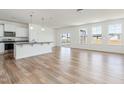 Bright open living space featuring hardwood floors, lots of natural light, and a kitchen with an island at 556 Winding Creek Dr Dr, Lillington, NC 27546