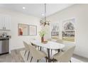 Elegant dining area featuring a modern chandelier, a marble-top table, and bright windows at 605 Lee St, Burlington, NC 27215
