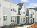 Modern townhouse exterior features a blue-gray color scheme with white accents, well manicured landscaping and inviting entryways at 608 Hyperion Aly, Wake Forest, NC 27587
