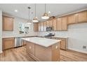 Modern kitchen features a large center island, stainless appliances, and ample cabinet space at 608 Hyperion Aly, Wake Forest, NC 27587