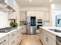Spacious kitchen featuring stainless steel appliances, light wood floors, and ample cabinet space at 696 The Parks Dr, Pittsboro, NC 27312