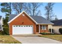 All brick home with an attached two car garage, and a well-manicured front lawn at 109 Kudrow Ln, Morrisville, NC 27560