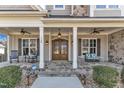 Inviting front porch with stone flooring, rocking chairs, and craftsman-style front door at 1100 Kingwood Dr, Raleigh, NC 27609