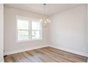 Bright dining room featuring modern chandelier, vinyl flooring, and large window at 120 Weavers Grove Dr, Chapel Hill, NC 27514