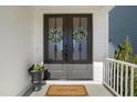 Elegant double front doors adorned with wreaths and 'welcome' mat enhance the home's entry at 140 Big Barn Dr, Wendell, NC 27591