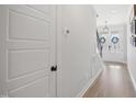Bright hallway featuring hardwood floors, white trim, and views of the front entry at 140 Big Barn Dr, Wendell, NC 27591