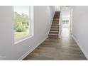 Bright hallway with stairs features modern flooring, a large window with a view, and neutral walls at 156 Fideaux Blvd # 248, Raleigh, NC 27603