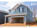 Two-story blue home featuring an unfinished two-car garage, brick foundation and gray home to the left at 2019 Cherry Creek Rd, Haw River, NC 27258