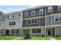Modern townhouses displaying shades of gray siding and brick foundations set against a sunny sky at 2241 Horton Park Dr, Apex, NC 27539