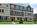 Attractive townhomes showcase a mix of gray tones, complemented by brick detail and green lawns at 2241 Horton Park Dr, Apex, NC 27539