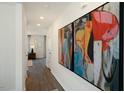 Inviting hallway featuring wood floors and colorful art pieces on the walls at 248 Oak Barrel St, Smithfield, NC 27577
