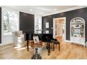 Elegant living room featuring a grand piano, hardwood floors, and arched windows, creating a sophisticated ambiance at 2511 Pineway Dr, Burlington, NC 27215