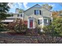 Charming home with lovely landscaping, a brick pathway, and a striking red front door at 2610 University Dr, Durham, NC 27707