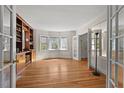 Spacious living room featuring hardwood floors, a bay window, and elegant french doors at 2610 University Dr, Durham, NC 27707