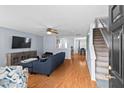Inviting living room with wood floors, a comfortable blue sofa, and easy access to the staircase at 3349 Tarleton W, Durham, NC 27713