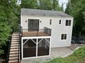 Exterior of home featuring a wood deck, screened porch and stone patio, surrounded by lush trees at 3412 Rock Creek Dr, Raleigh, NC 27609