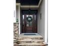 Elegant wooden front door with glass panels and decorative wreath, a warm welcome to visitors at 3805 Watermark Dr, Franklinton, NC 27525