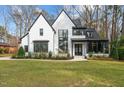 Beautiful exterior view with a manicured front lawn, landscaped plantings and black trim windows at 4208 Windsor Pl, Raleigh, NC 27609