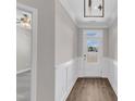 Bright entryway with white wainscoting, wood-look flooring, and modern light fixture at 507 Gateway Townes Blvd, Wake Forest, NC 27587