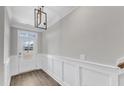 Bright, neutral-toned entryway featuring wainscoting and a stylish pendant light fixture at 507 Gateway Townes Blvd, Wake Forest, NC 27587