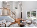 Inviting living room featuring a soaring ceiling, hardwood floors, and a staircase at 5915 Eaglesfield Dr, Raleigh, NC 27613