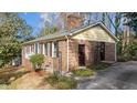 Brick home featuring a chimney, clean roofline, and side entrance at 6404 Dixon Dr, Raleigh, NC 27609