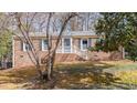 Charming brick home featuring green shutters and a welcoming front porch at 6404 Dixon Dr, Raleigh, NC 27609