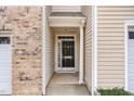 Covered entrance featuring a black front door, brick accents, and neutral siding at 705 Keystone Park Dr # 51, Morrisville, NC 27560