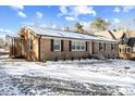 Well-maintained brick home with covered side entrance, black shutters, and snowy yard at 7103 Big Horn Dr, Hillsborough, NC 27278