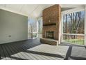 Cozy screened porch featuring a brick fireplace and open views of the surrounding trees at 7112 Camp Side Ct, Raleigh, NC 27613