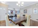 Light-filled dining area with wood floors, complemented by a chandelier and views to the living room at 714 Cupola Dr, Raleigh, NC 27603