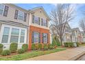 Charming townhome with well-maintained lawn, manicured bushes, and a sidewalk leading to other homes at 714 Cupola Dr, Raleigh, NC 27603