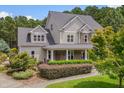 A beautiful two-story home with stone accents, complemented by lush landscaping and mature trees at 7400 Bleasdale Ct, Apex, NC 27539