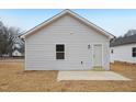 Exterior view of a house showing light gray vinyl siding and a concrete patio slab at 815 Graham St, Burlington, NC 27217