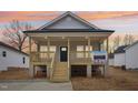 Inviting front elevation featuring a raised, covered porch with stylish wood railings at 815 Graham St, Burlington, NC 27217