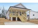 Beautifully constructed home with wood porch and stairs, complemented by light gray siding at 815 Graham St, Burlington, NC 27217