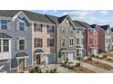 Townhome exteriors showcasing a cohesive design with varied colors, garages, and landscaping at 905 Arnold Place Dr, Fuquay Varina, NC 27526