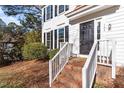 Inviting brick front porch with white railings leading to a black front door at 105 Solstice Cir, Cary, NC 27513