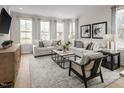 Stylish living room with large windows, neutral walls, comfortable seating, and modern decor at 1402 Chowan Ave, Durham, NC 27713