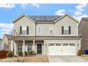 Charming two-story home featuring solar panels, a two-car garage, and a cozy front porch at 1610 Stone Rd, Durham, NC 27703
