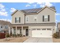 Beautiful two-story home featuring solar panels, a two-car garage, and a welcoming covered porch at 1610 Stone Rd, Durham, NC 27703