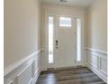 Entryway with a white front door and sidelights, and laminate wood flooring at 1749 Daiquiri Turn, Sanford, NC 27332