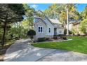 Landscaped home exterior featuring a long driveway and stone and siding accents at 206 Steep Bank Dr, Cary, NC 27518