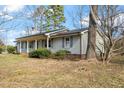 Quaint single-story home with a covered front porch, complemented by mature trees and garden shrubs at 245 Cedar Crk Rd, Franklinton, NC 27525