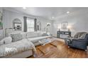 Bright living room with hardwood floors, a plush sofa, and an open flow to other living spaces at 2836 Oberlin Rd, Raleigh, NC 27608