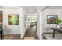 Hallway with hardwood floors leading to a bright living area, showcasing modern interior design at 302 Umstead St, Sanford, NC 27330