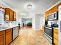 Well lit kitchen with stainless steel appliances, wood cabinets, and spacious countertops at 401 Maymount Dr, Durham, NC 27703