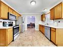 Efficient kitchen layout with stainless steel appliances, wood cabinetry, and durable floor at 401 Maymount Dr, Durham, NC 27703